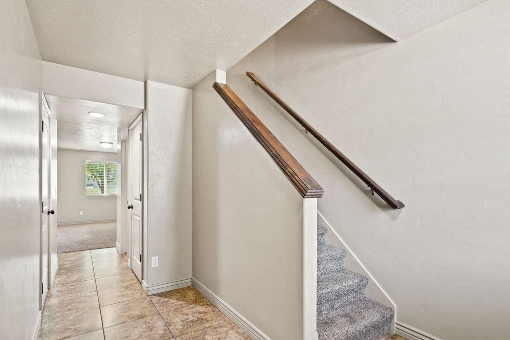 the entryway of a house with stairs and a hallway with a door