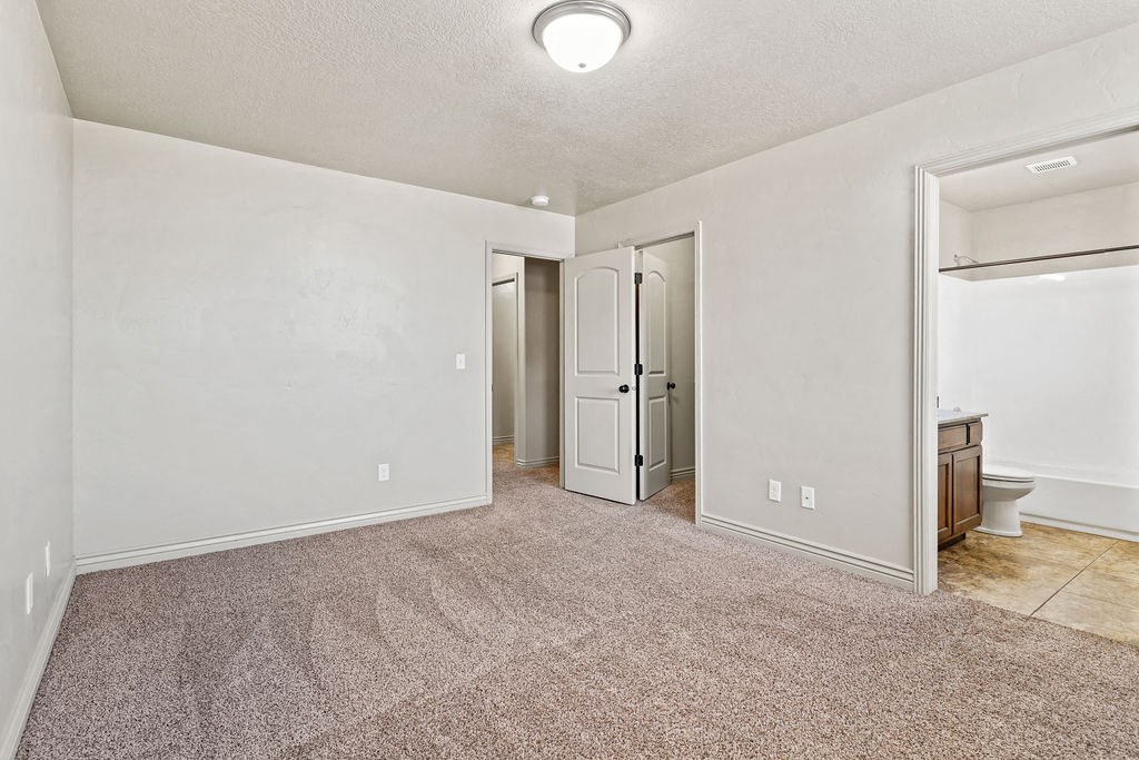 an empty living room with a door to the bathroom