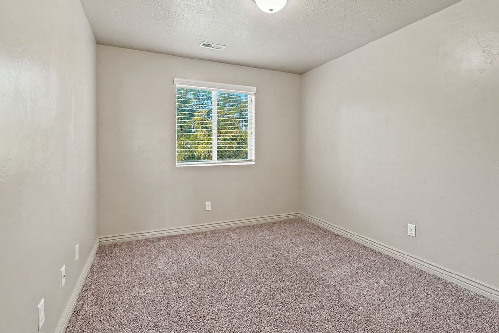 an empty room with a window and carpet