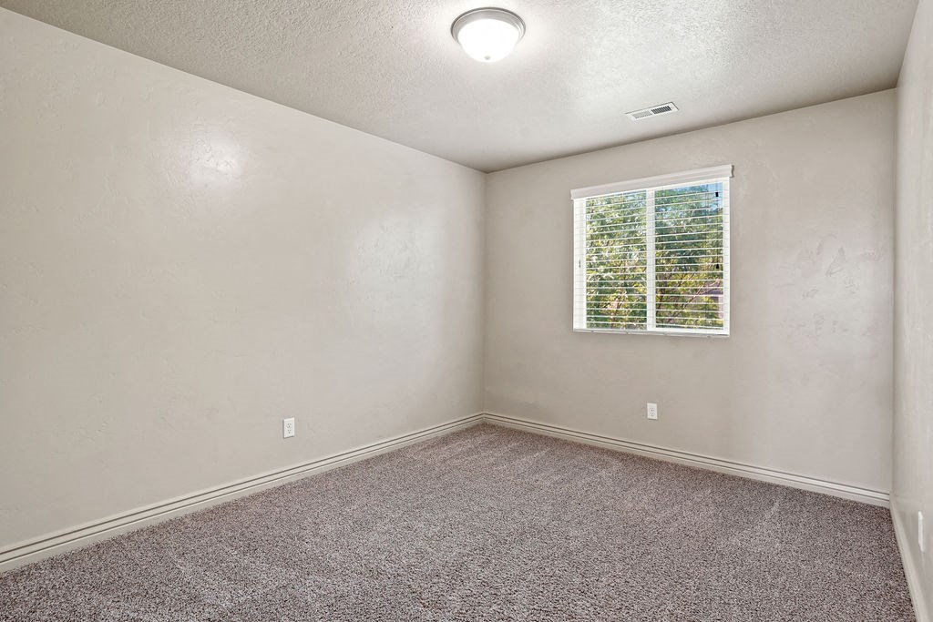 an empty room with carpet and a window