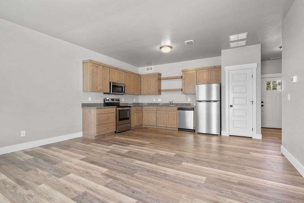 a kitchen with wooden cabinets and a stainless steel refrigerator