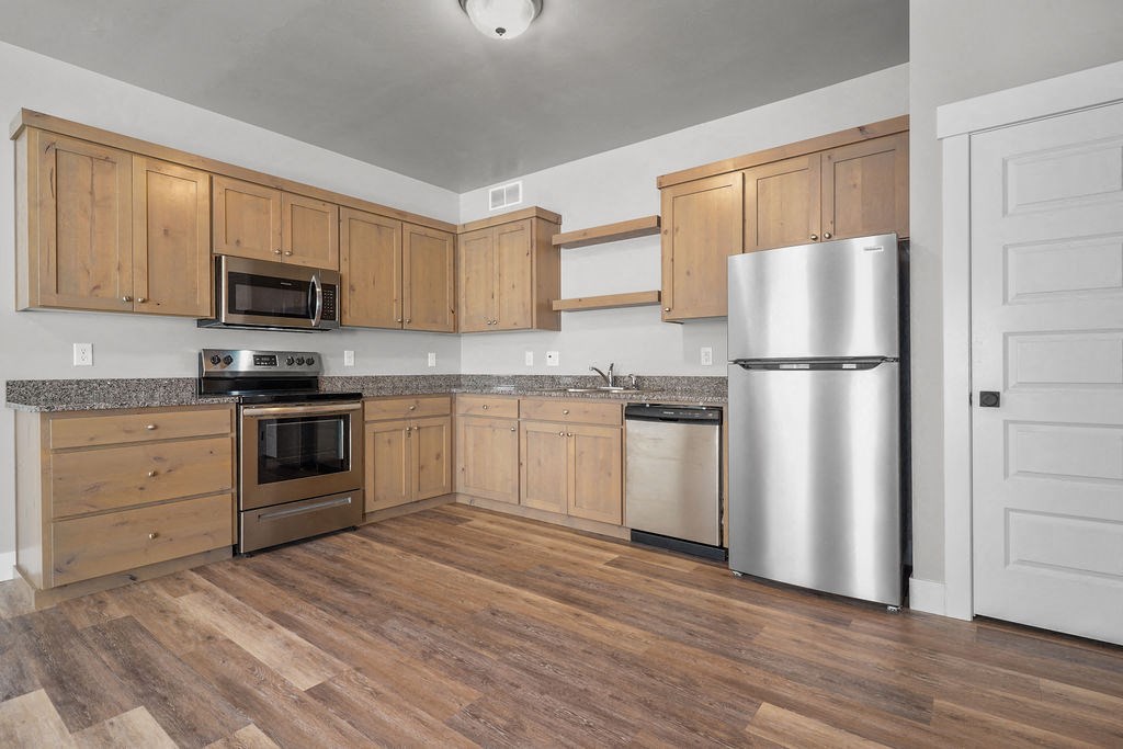 a kitchen with wooden cabinets and stainless steel appliances