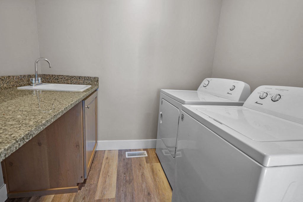 a laundry room with a sink and a washer and dryer