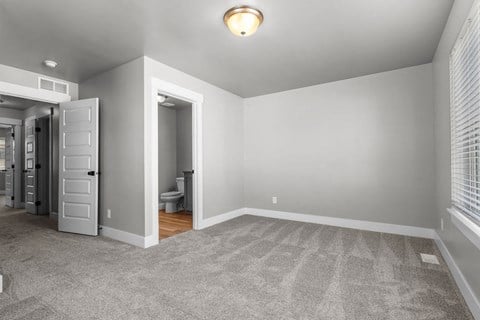 a bedroom with a closet and a door to a bathroom