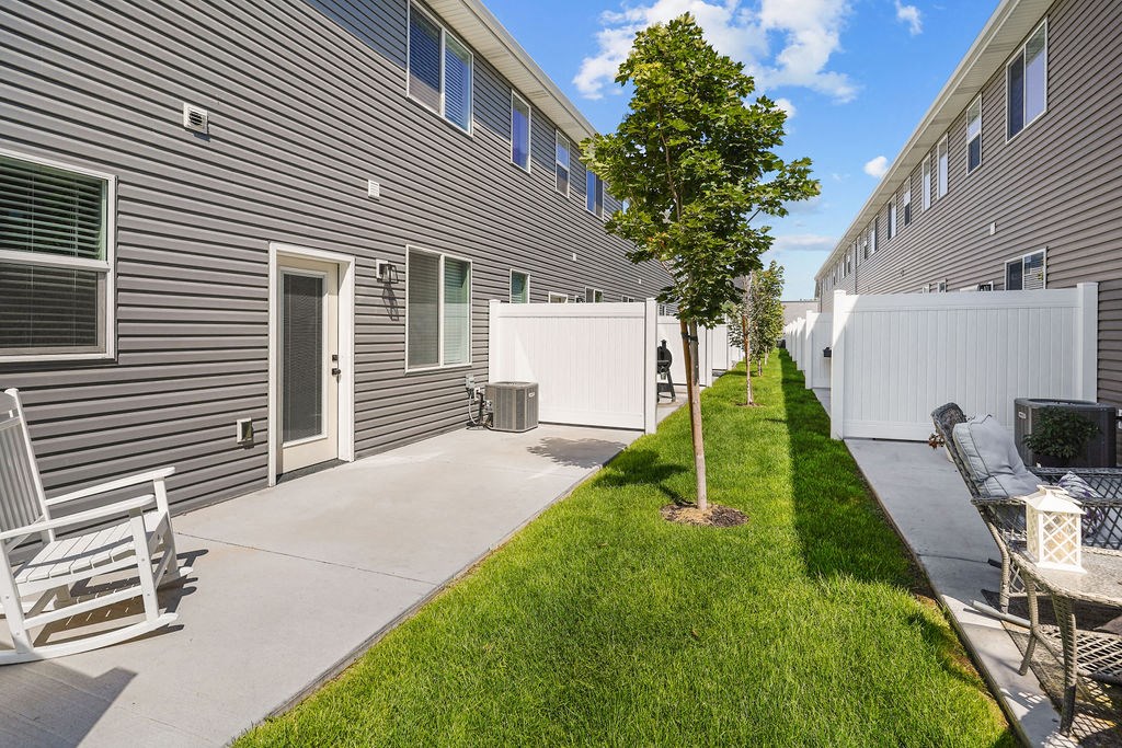 the yard of a home with a patio and a tree