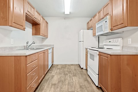 A kitchen with wooden cabinets and white appliances.