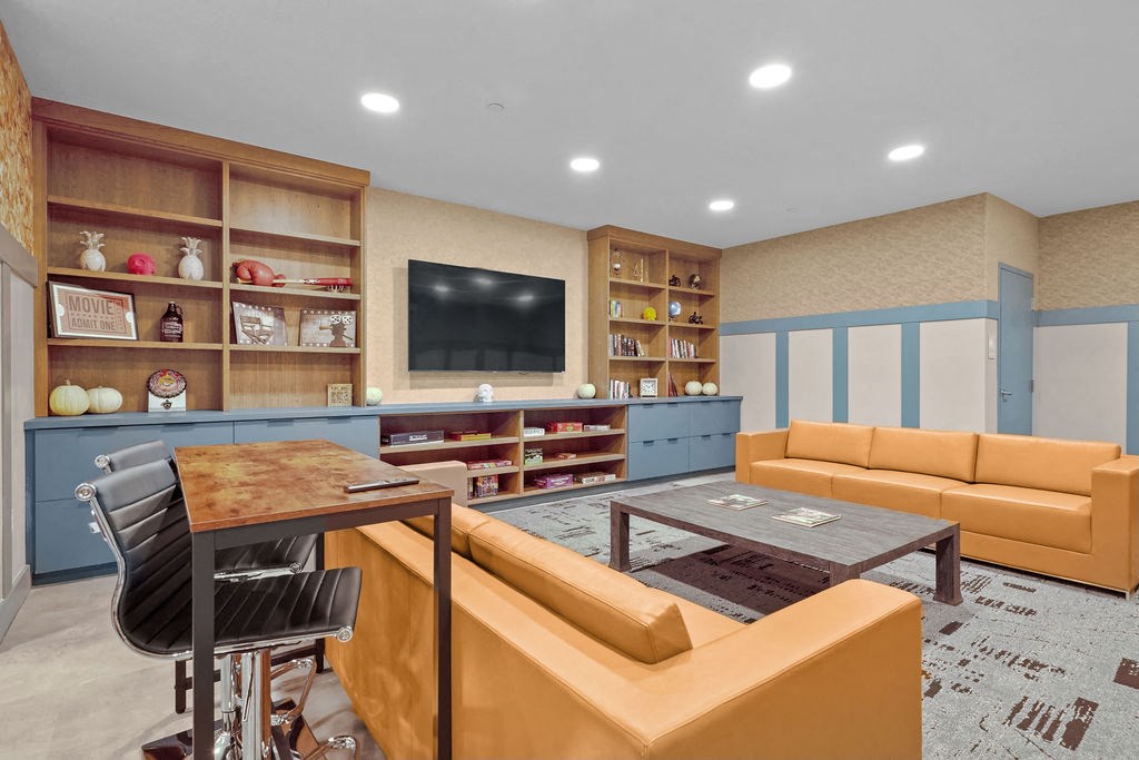 A living room with a brown table and orange couch.