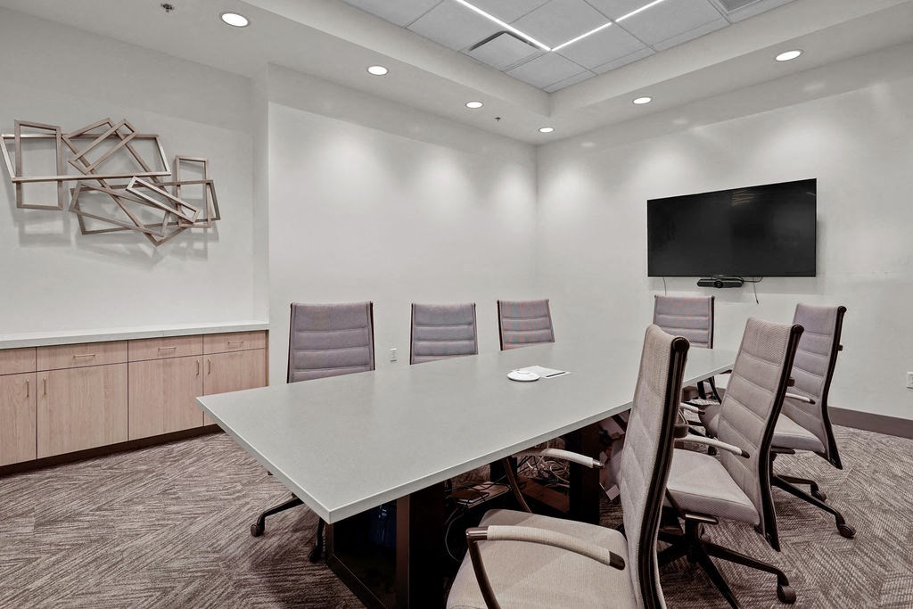 A conference room with a large table and chairs.