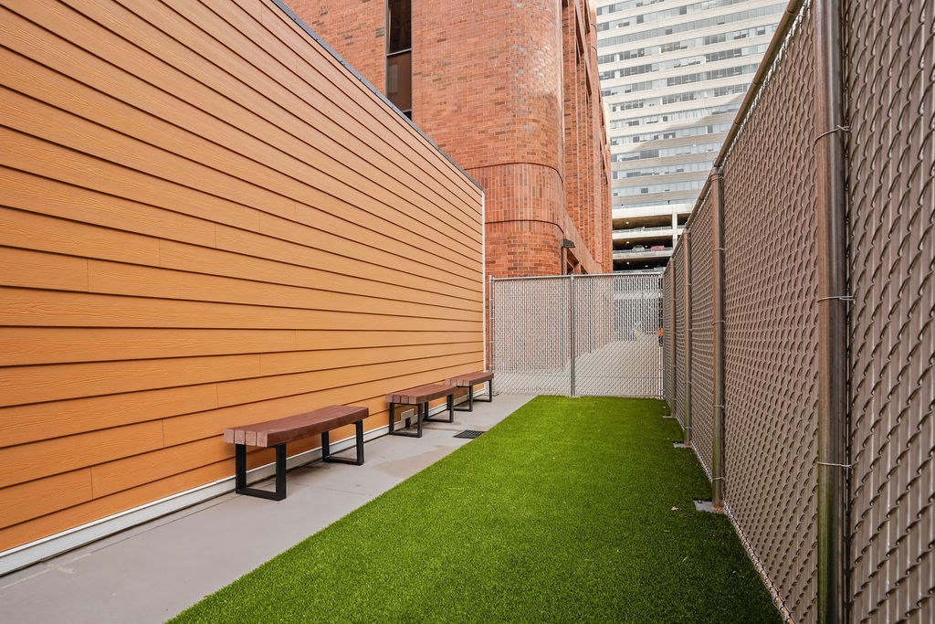 A long corridor with benches and a fence.