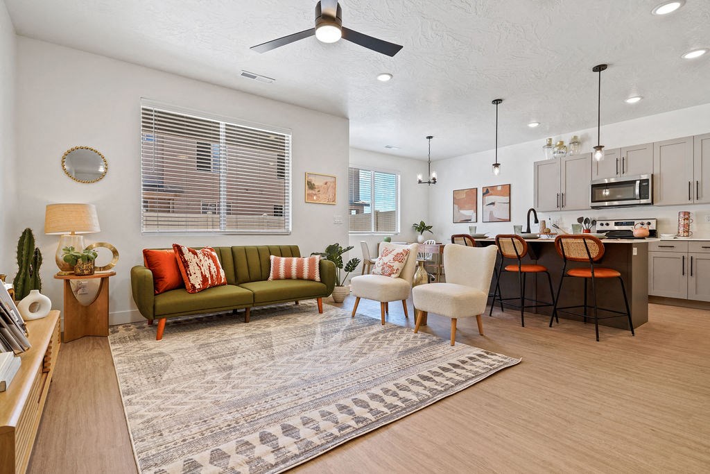 a living room and kitchen with a couch and chairs