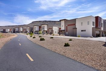 A road with a yellow line in the middle runs through a housing development.