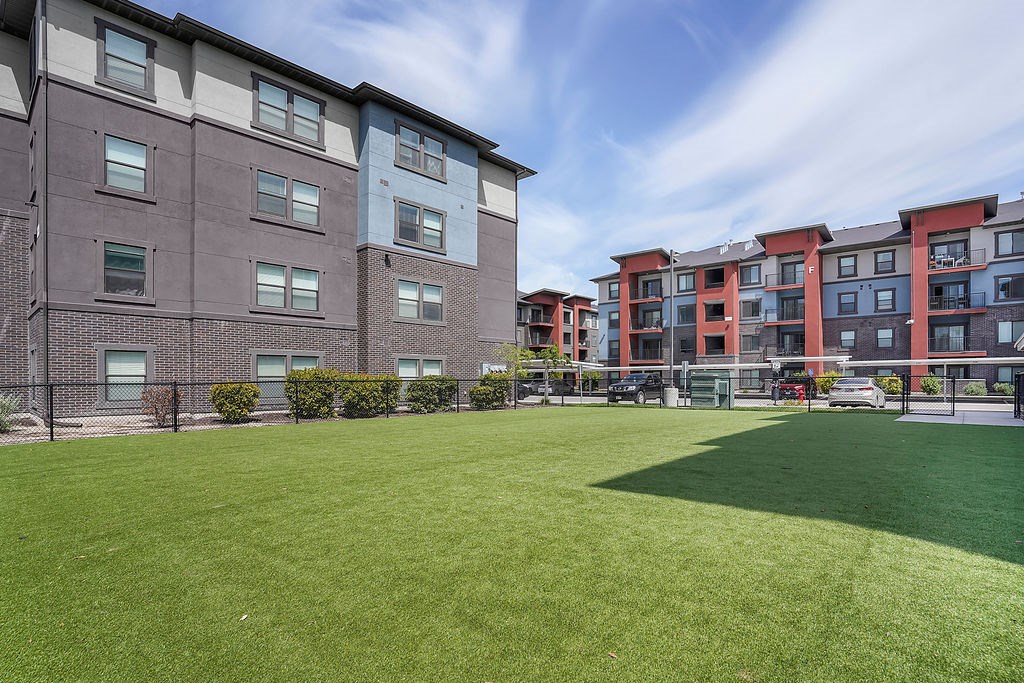 A large grassy area in front of apartment buildings.