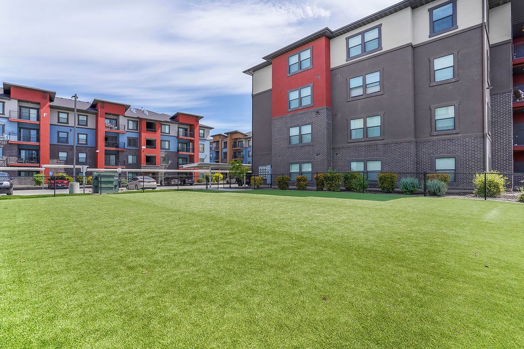 A grassy area in front of apartment buildings.