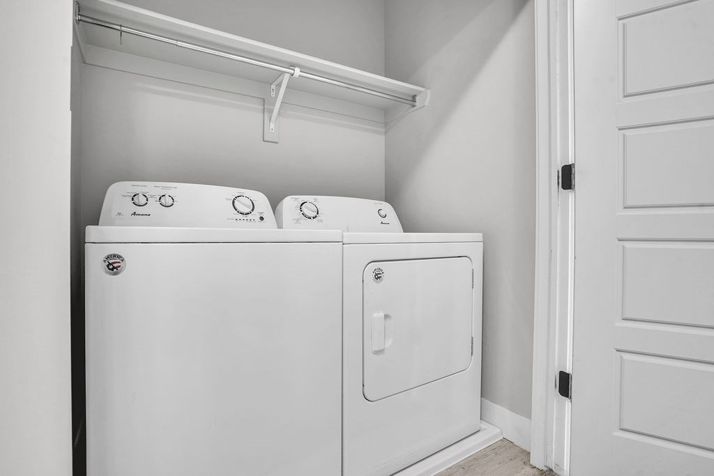 A white washing machine and dryer in a small laundry room.