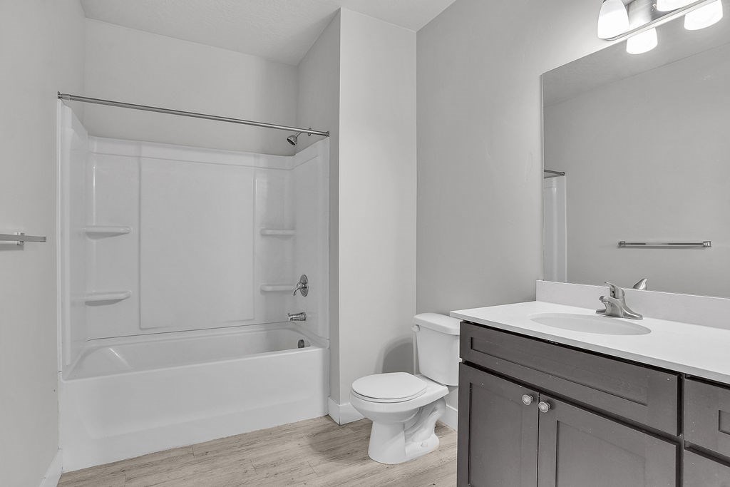 A white bathroom with a toilet, sink, and bathtub.
