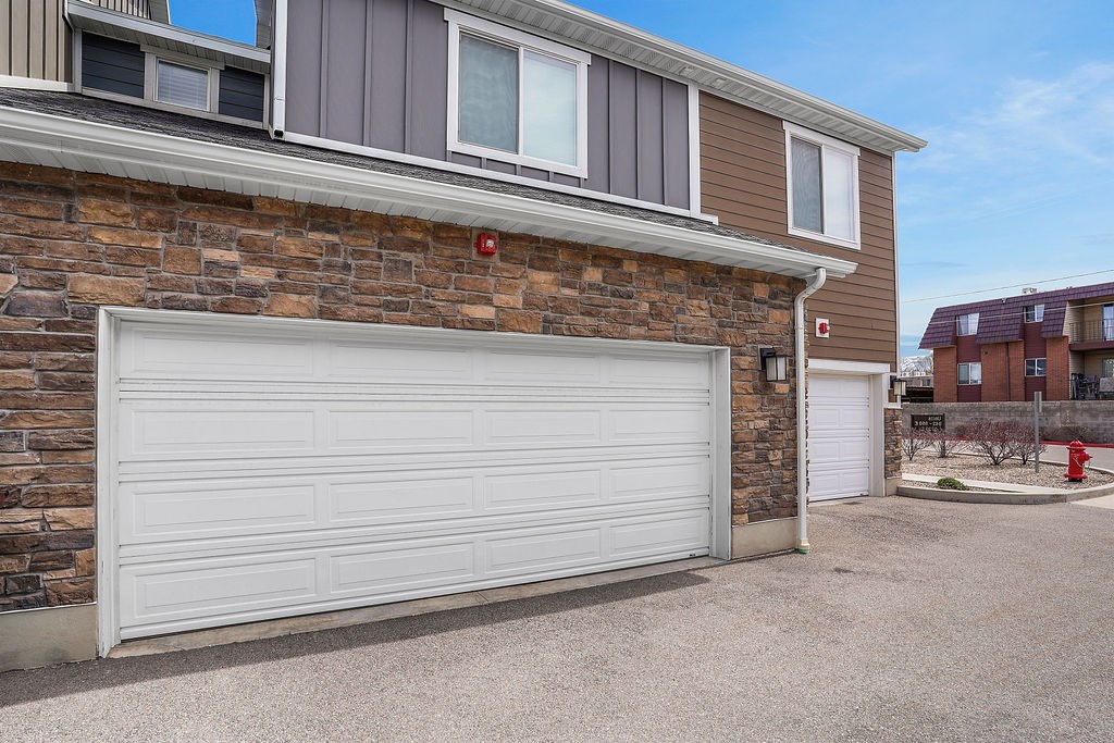 A garage door is closed in front of a brick wall.