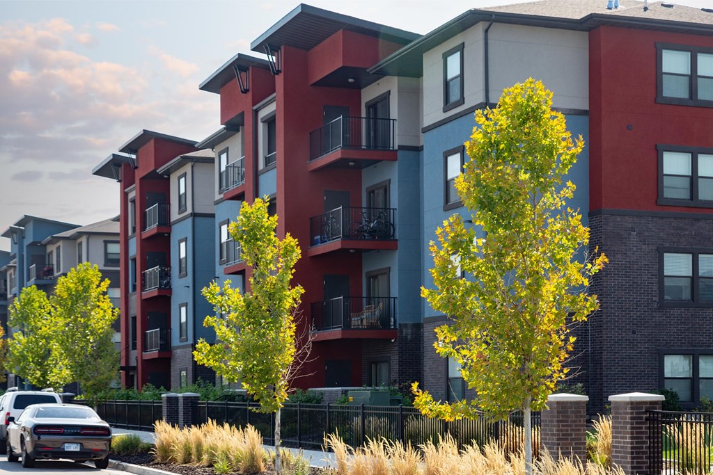 A row of modern apartment buildings with trees in front.