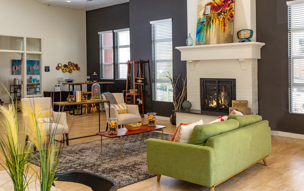 A living room with a green couch and a fireplace.