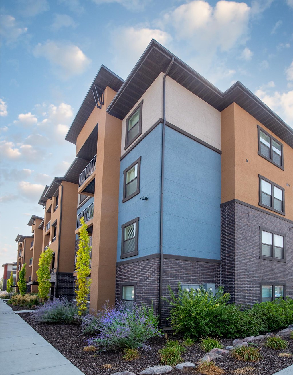 A modern apartment building with a mix of blue and brown exterior walls.