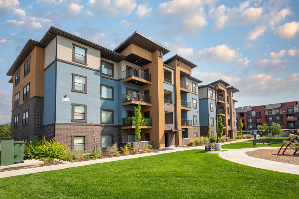 Apartment complex with a green lawn in front.