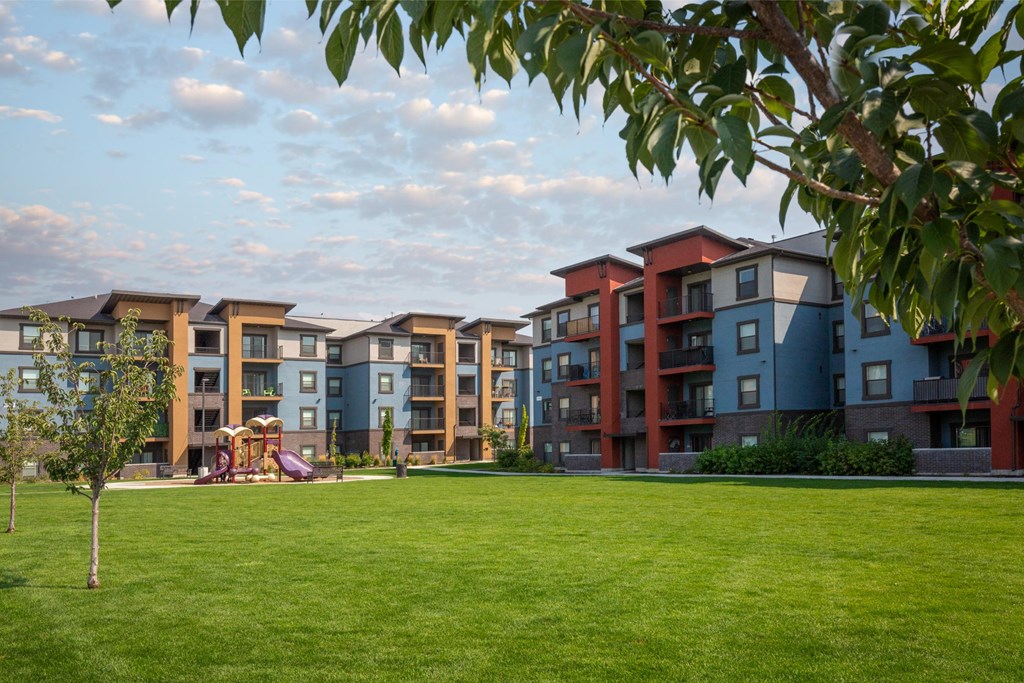 Apartment complex with a playground in the foreground.