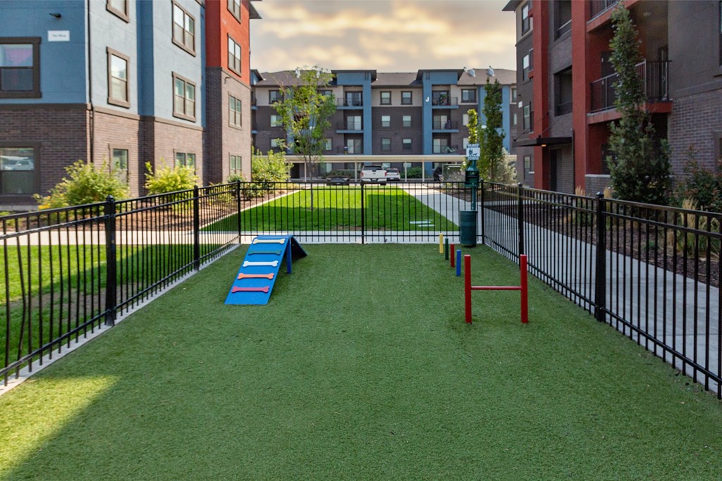 A playground with a blue slide and red climbing frame.