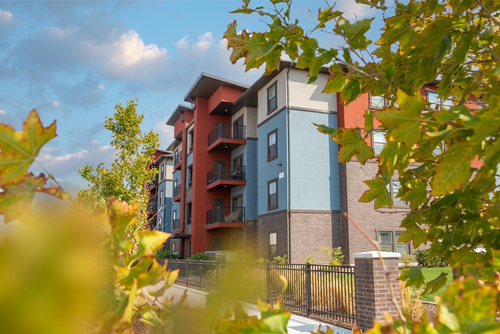 A modern apartment building with a black fence in front.