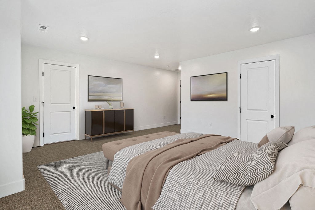the master bedroom has white walls and white doors and a bed