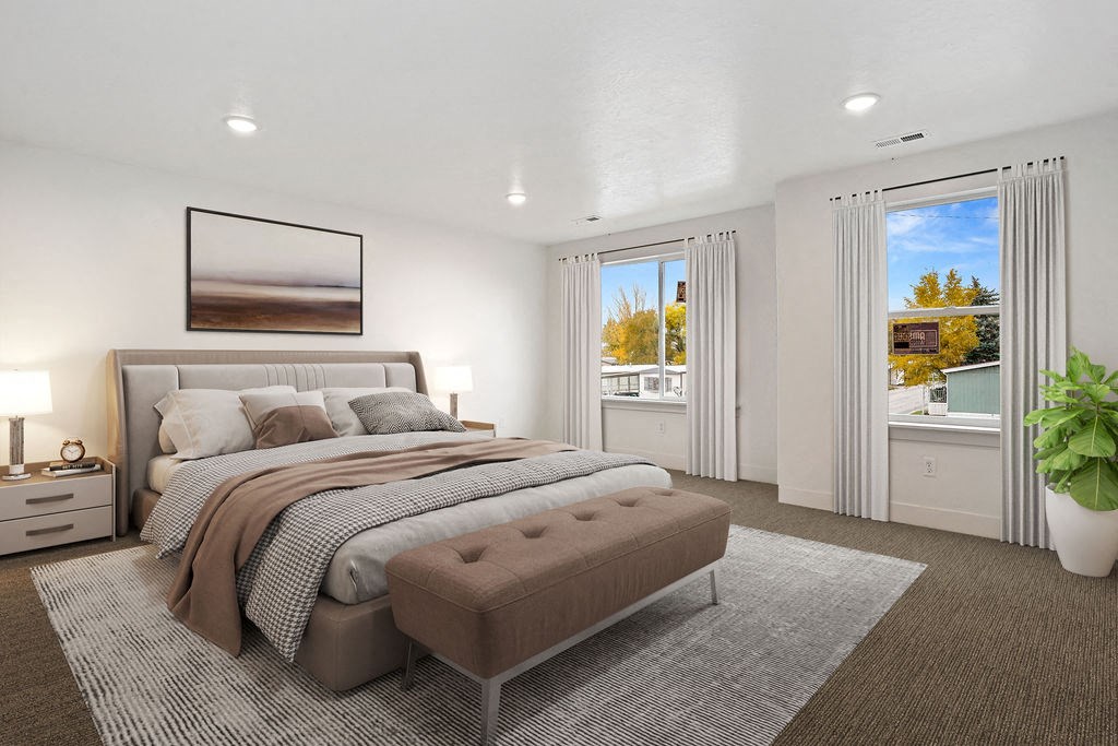 a bedroom with a bed and two windows