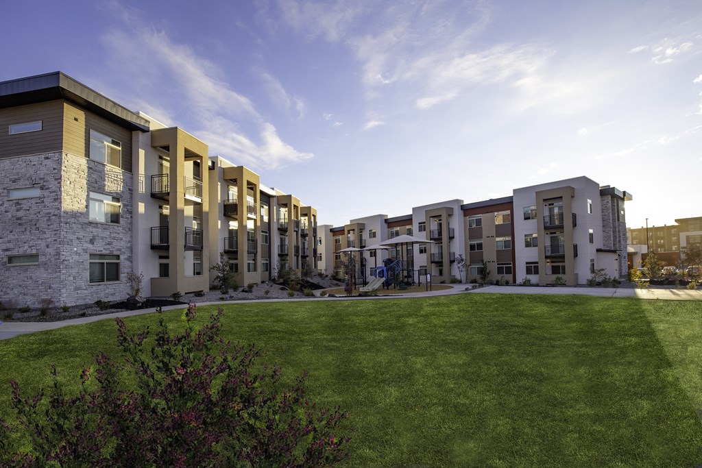 a view of an apartment courtyard with a green lawn