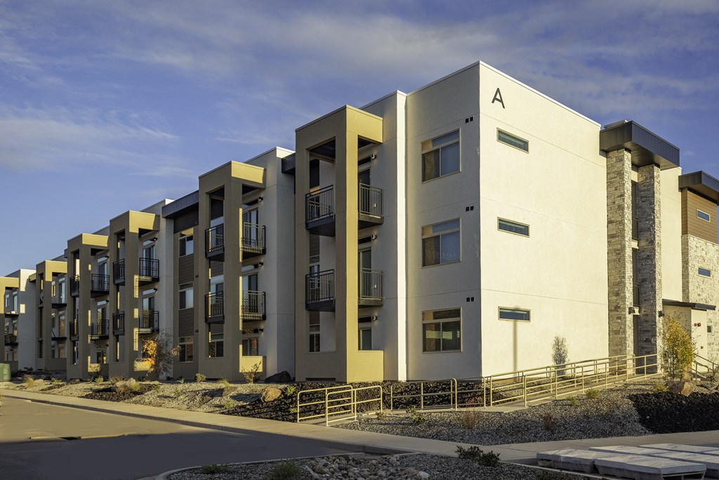 a row of modern apartments with balconies and a sky background
