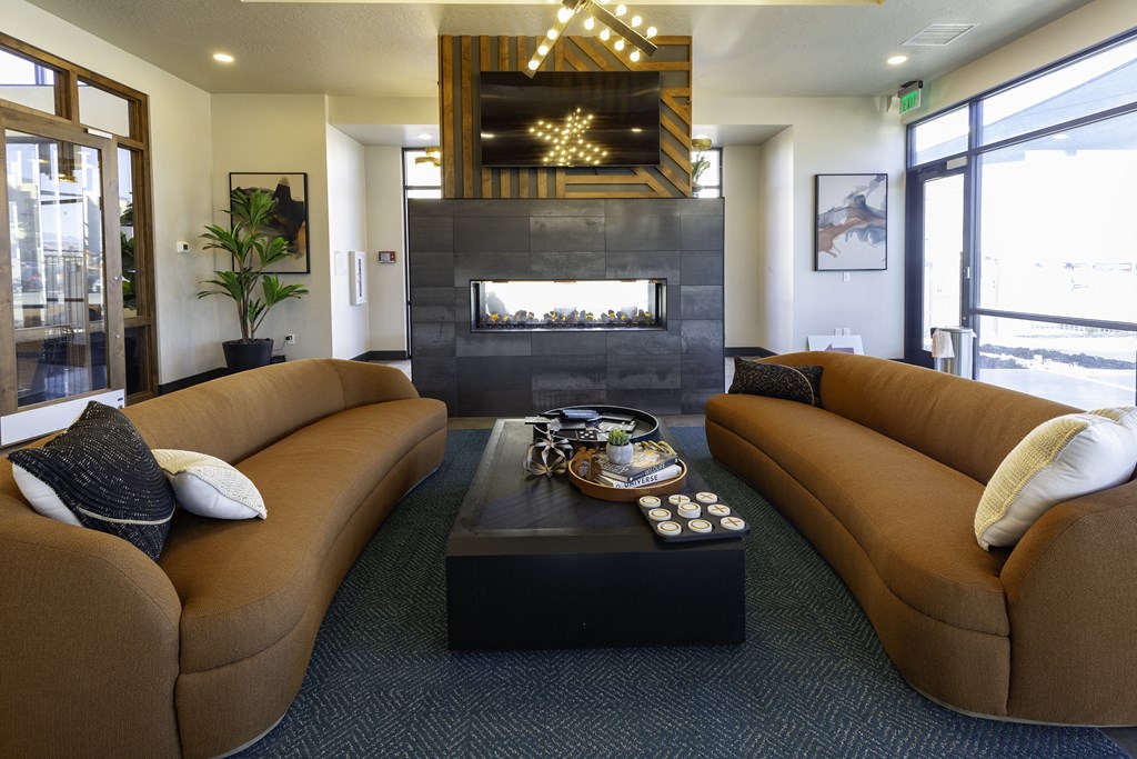 a living room with brown couches and a fireplace