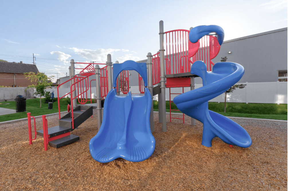 a playground with a blue slide and a red