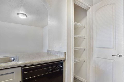 A kitchen with a black oven and white cabinets.