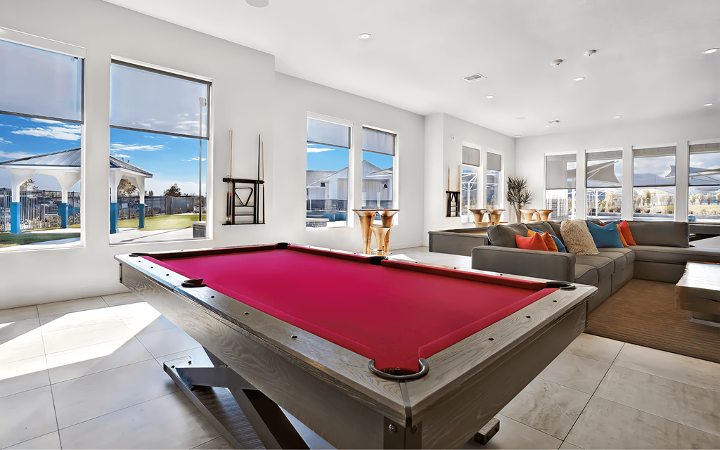 A pool table in a room with a view of the outside.