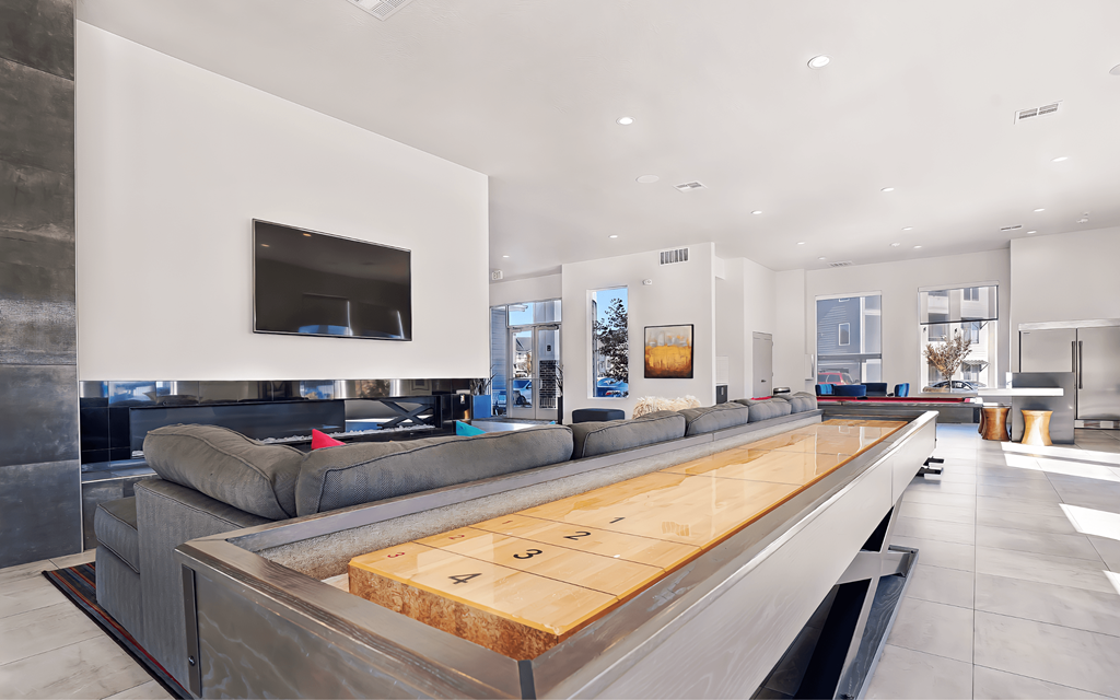 A modern living room with a long wooden table in the center.