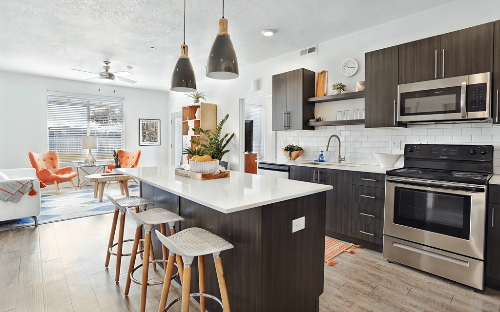 A kitchen with a white countertop and a stainless steel oven.