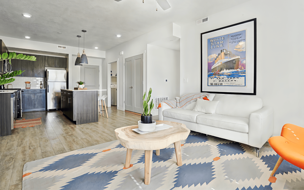A living room with a white couch and a framed poster on the wall.