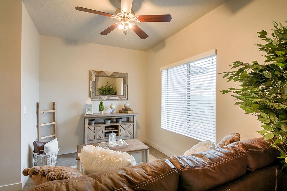 a living room with a ceiling fan and a large window