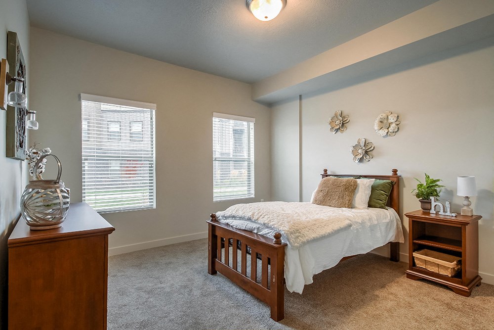 a bedroom with a bed and two windows