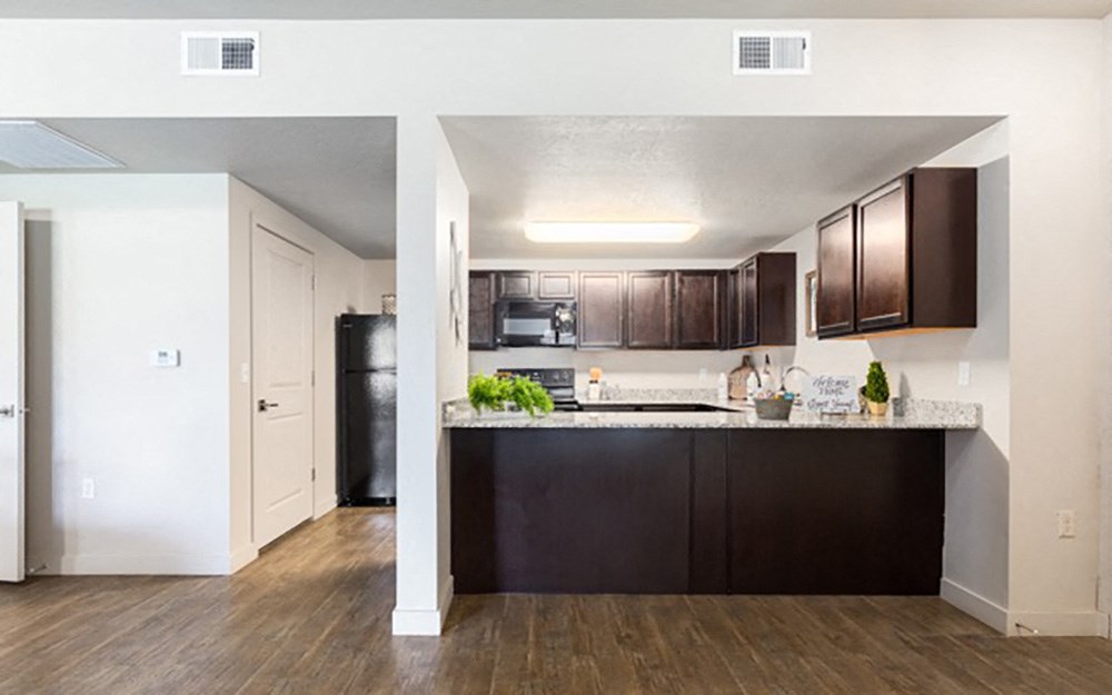 a kitchen with dark wood cabinets and a white counter top