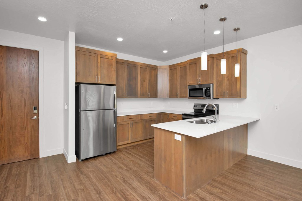 a kitchen with wooden cabinets and a stainless steel refrigerator