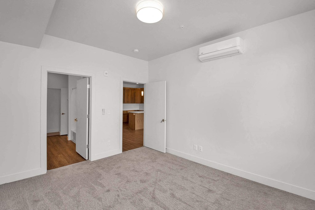 a bedroom with white walls and a carpeted floor