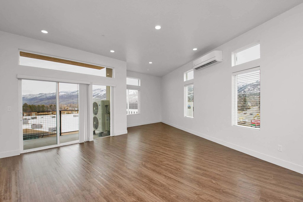 a living room with a hardwood floor and white walls