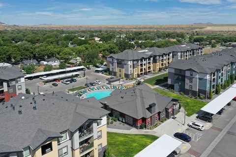 an aerial view of a large apartment complex with a pool and parking lot