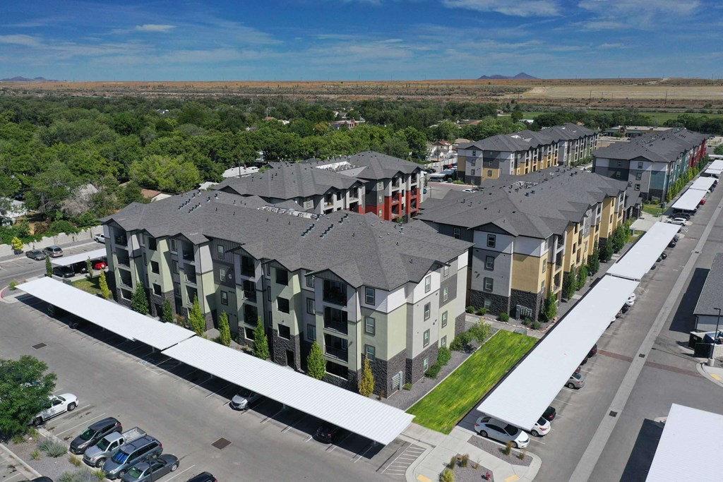 an aerial view of a row of apartment buildings with trees in the background
