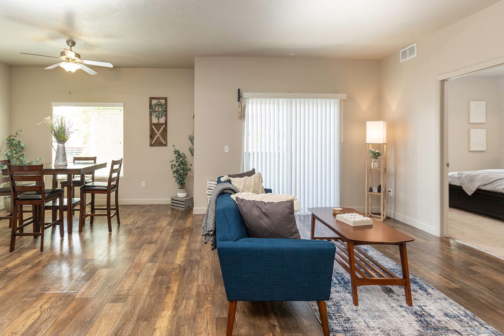 a living room and dining room with hardwood floors and a ceiling fan