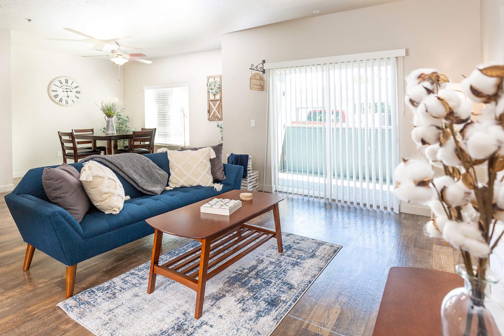 a living room with a blue couch and a wooden coffee table