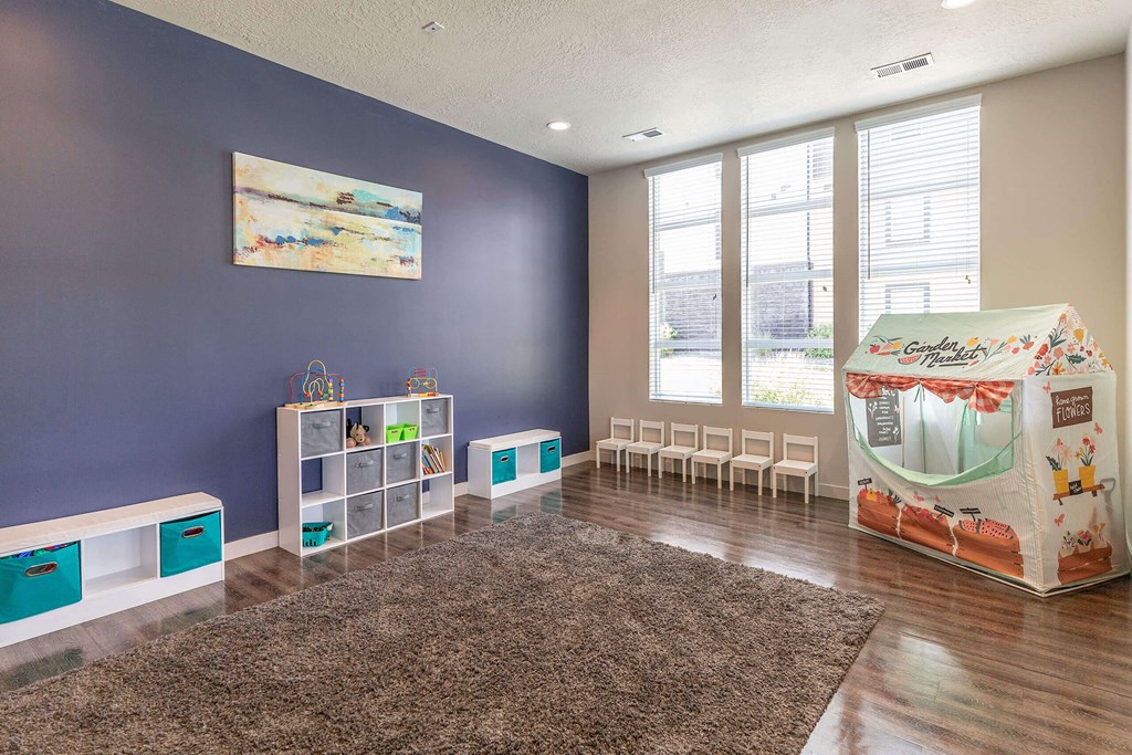 a playroom with a play table and chairs and a large window