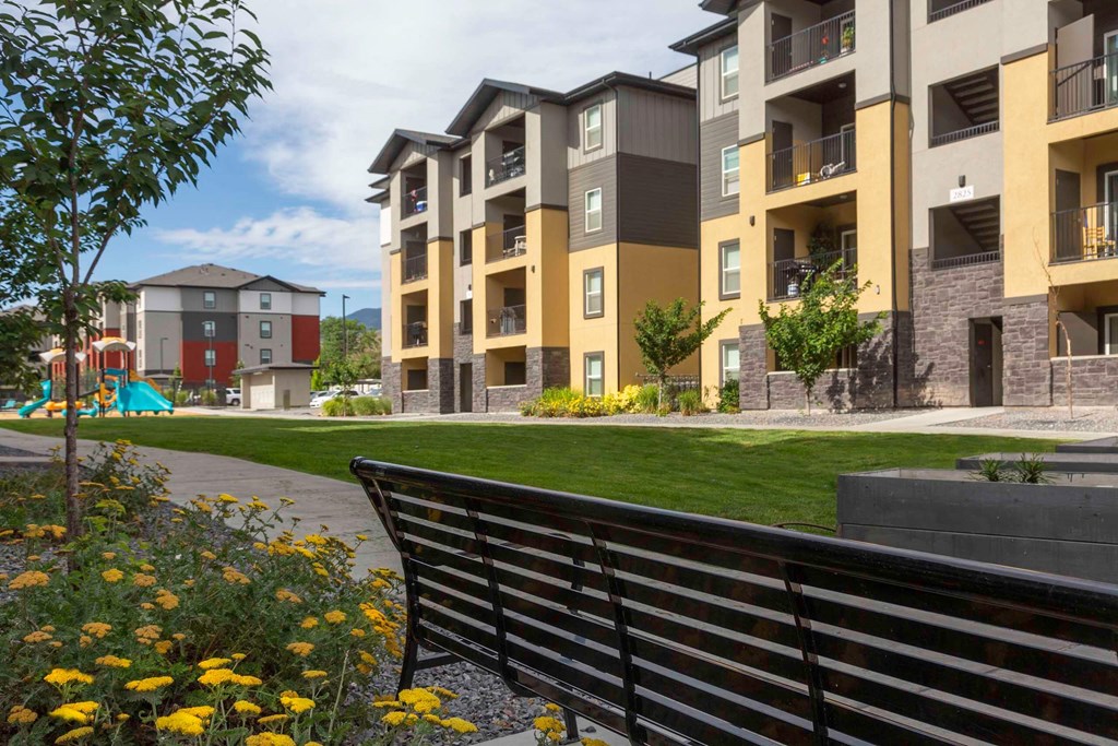 a park bench in front of an apartment complex